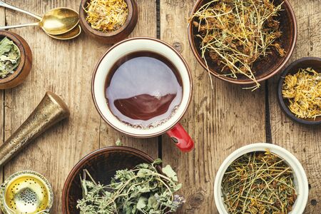 Cup with tea from medicinal herbs on a wooden backgroundの写真素材