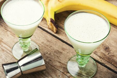 Homemade ripe banana liquor on a wooden background.の写真素材