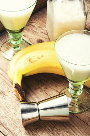 Homemade ripe banana liquor on a wooden background.の写真素材
