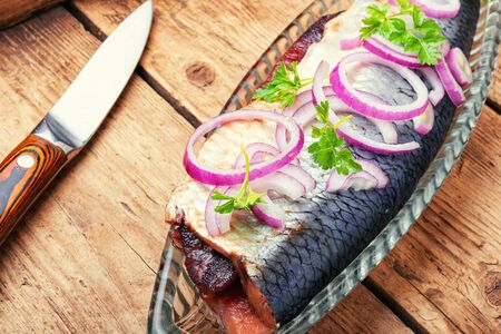 Salted herring with red onion on old wooden backgroundの写真素材