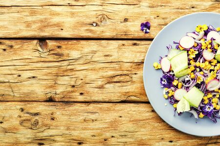 Salad with red cabbage, radish, corn, cucumber and flowersの写真素材