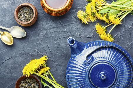 Ceramic teapot with herbal tea from flowering dandelions.Herbal tea from dandelionsの写真素材