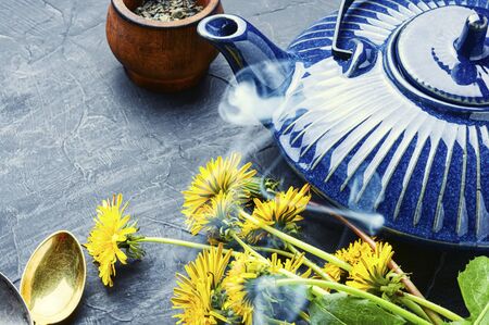 Ceramic teapot with herbal tea from flowering dandelions.Herbal tea from dandelionsの写真素材