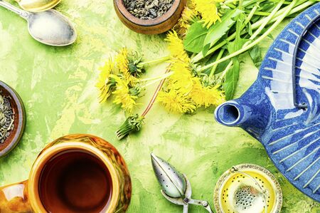 Ceramic teapot with herbal tea from flowering dandelions.Herbal tea from dandelionsの写真素材