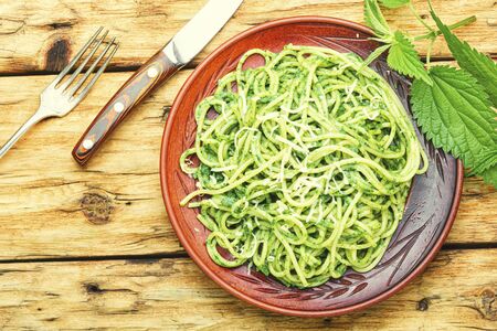 Italian traditional pasta with herb nettle sauce.Green pasta on wooden table.の写真素材