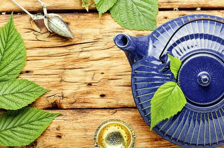 Healing herbal tea made from fresh raspberry leaf.Glass teapot with herbal teaの写真素材