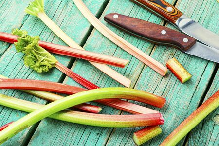 Fresh rhubarb stem on retro wooden table.Bundle of stalks and pieces rhubarbの写真素材