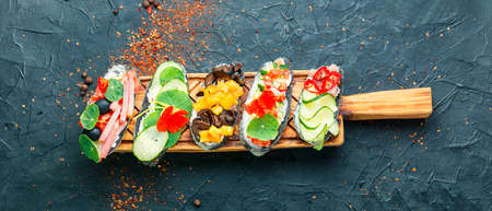 Summer bruschettas or canape with cream cheese,bacon and vegetables.Traditional italian bruschetta