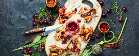 Baked chicken meat in a cherry sauce with herbsの写真素材