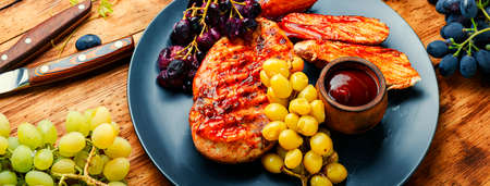 Sliced chicken breast with grapes on rural wooden tableの写真素材
