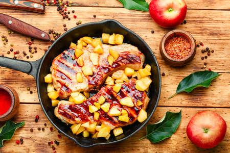 Pork entrecote cooked with aromatic autumn apples. Appetizing meat with caramelized apples.の写真素材