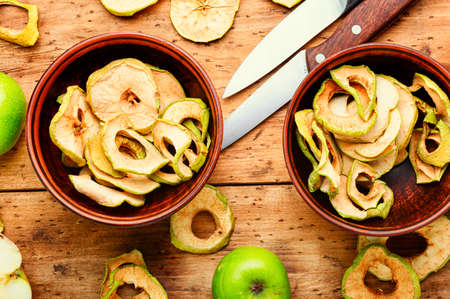 Apple chips on rustic wooden background. Dried applesの写真素材