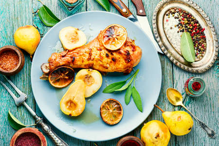 Baked turkey leg with caramelized pear.Appetizing meat dish.の写真素材