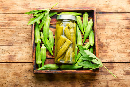 Homemade autumn vegetable preservation.Pickled okra on wooden tableの写真素材