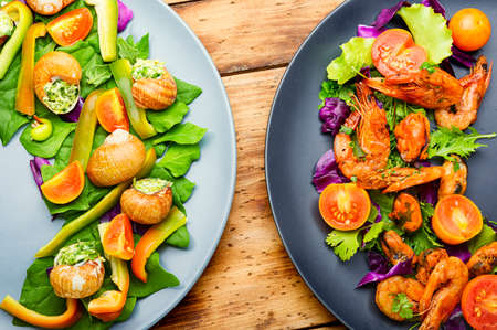 Appetizing salad with spinach, tomato, pepper and snails.の写真素材