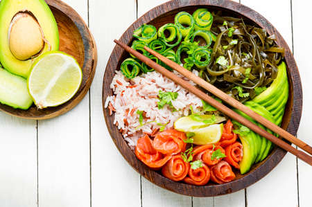 Hawaiian salmon poke bowl with rice, seaweed and avocadoの写真素材