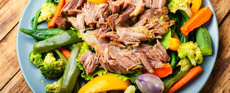 Appetizing beef stew with seasonal vegetables on wooden table