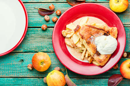 Piece of apple pie with ice cream on rustic wooden backgroundの写真素材