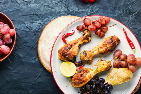 Baked chicken legs with grapes. Roasted chicken legs on plateの写真素材
