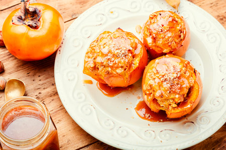 Persimmon stuffed with granola and caramel sauce. Tasty baked persimmon.の写真素材