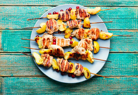 Fried turkey meat with apple on wooden skewers.Appetizing barbecue.の写真素材
