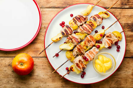 Delicious turkey shish kebab with apple on rural wooden tableの写真素材