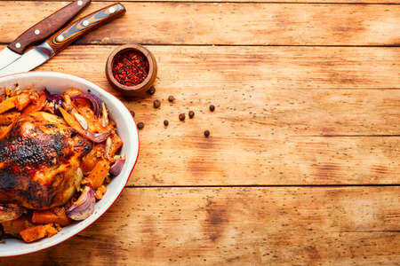 Appetizing whole baked partridge with pumpkin.Fried chicken with pumpkin.Copy spaceの写真素材