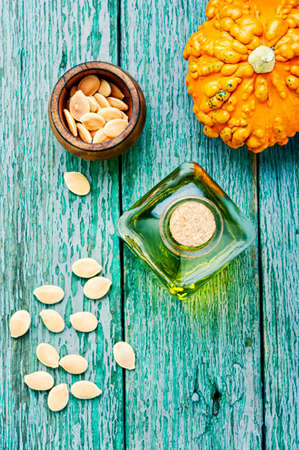 Pumpkin oil in bottle, raw pumpkin and pumpkin seedsの写真素材
