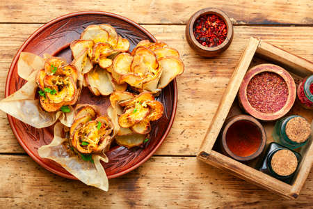 Fried potato with bacon on plate over wooden tableの写真素材