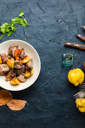 Delicious fried liver with quince pieces in a plateの写真素材