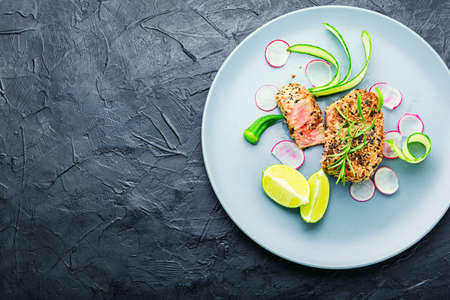 Baked tuna steak with vegetable garnish. Fish cooked with vegetables.の写真素材