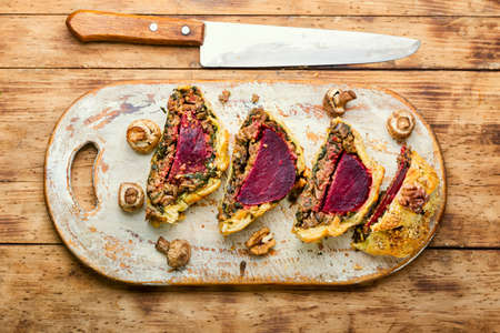 Delicious beetroot pie sliced on a kitchen board. Wellington pie.の写真素材