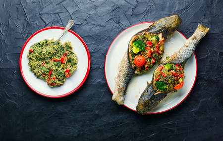 Delicious roasted fish stuffed with broccoli, quinoa and tomatoの写真素材