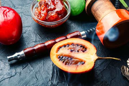 Smoking hookah with tamarilla flavor.Fruit hookah tobacco.Trendy hookahの写真素材