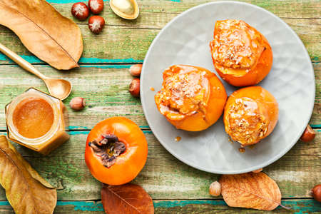 Persimmon stuffed with oatmeal with caramel sauce.Baked persimmon.Autumn dessert.の写真素材