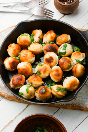 Fried dumplings stuffed with beef meat.Tasty roasted pelmeni on iron cast panの写真素材