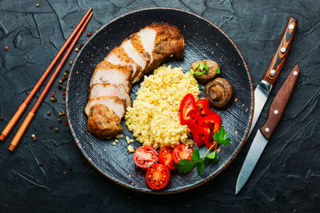 Appetizing meat steak with bulgur porridge and vegetablesの写真素材