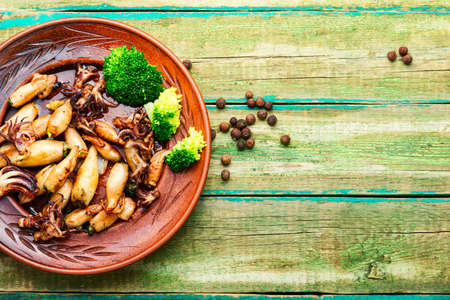 Baked squid stuffed with broccoli.Grilled calamari with vegetables.Seafood