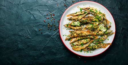 Fried capelin fish with herbs and lemon zest.Fish dish