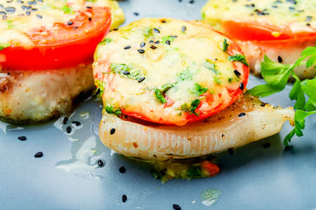 Fish baked with cheese, tomato and herbs.Roasted pangasius.Grilled white fishの写真素材