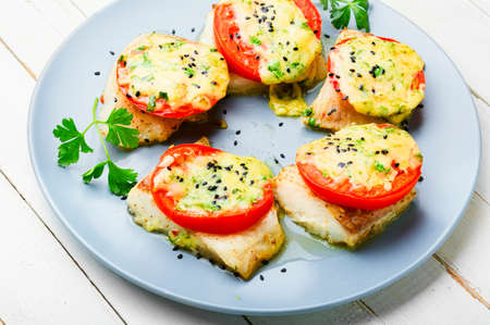 Slice of fish baked with cheese, tomato and herbs. Roasted pangasiusの写真素材