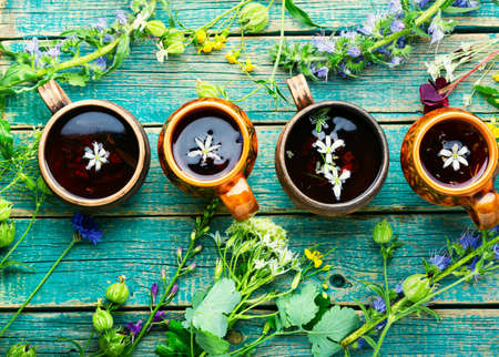Herbal tea from wild flowers on an old vintage wooden table. Herbal medicine, herbalismの写真素材