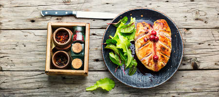 Roasted chicken breast with cherry sauce. Baked chicken meat in berries on old wooden table. Flat layの写真素材
