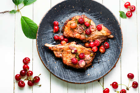 Pork steak on the bone roast in berry marinate.Meat in cherry wine sauceの写真素材