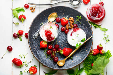 Summer dessert, ice cream with strawberries and cherries.Ice cream with berry jamの写真素材