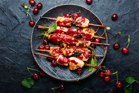 Chicken meat on wooden skewers in cherry sauce.の写真素材