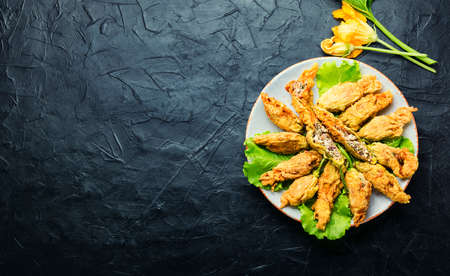 Fried zucchini flowers stuffed with cheese and herbs. Space for textの写真素材