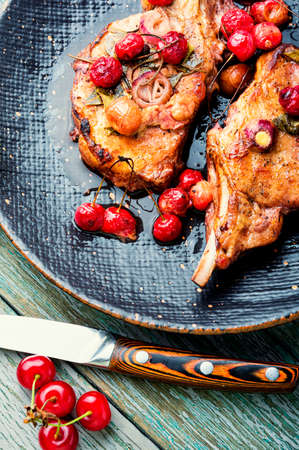Pork meat on the bone roast in berry marinate Grilled pork steaks in cherry wine sauceの写真素材