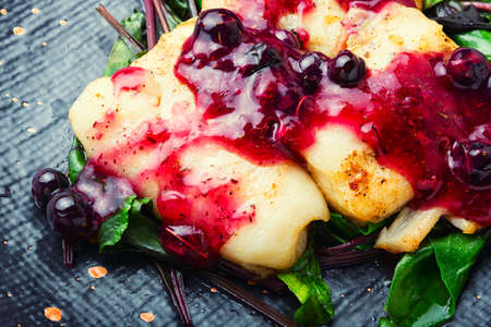 Delicious baked fish with berry sauce. Stewed pangasius with blueberries