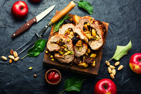 Sliced meatloaf with apples, dates and pistachios on cutting board. Baked lean meat.の写真素材